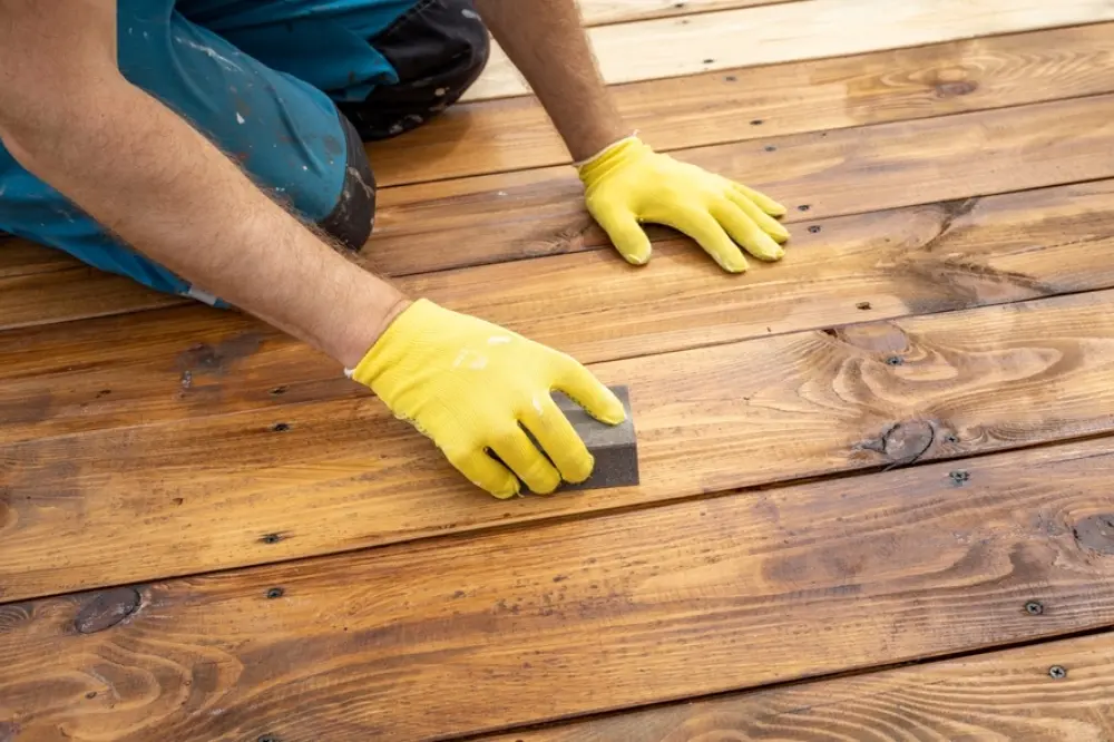 Contractor repairing and renovating an outdoor wooden deck to improve safety and appearance.