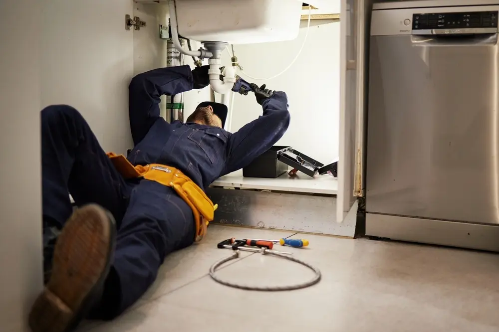 Professional plumber repairing household plumbing fixtures and pipes to restore proper water flow