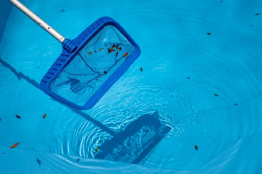 Pool maintenance specialist cleaning and servicing a residential swimming pool